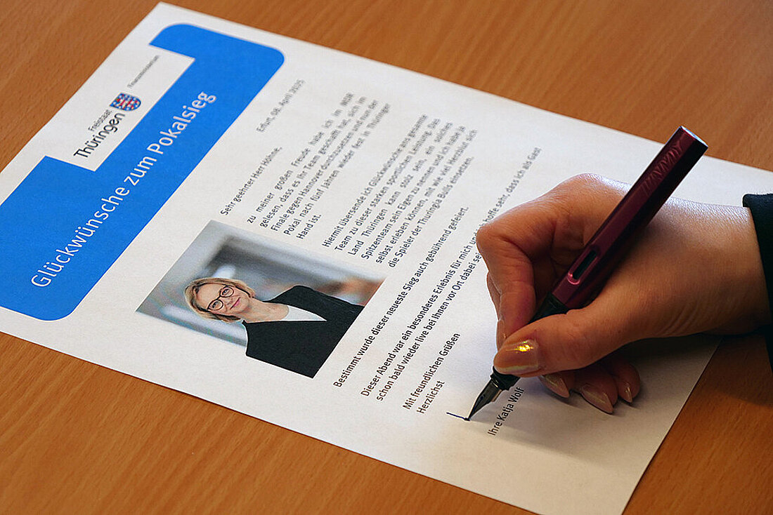 Das Glückwunschschreiben wird unterschrieben