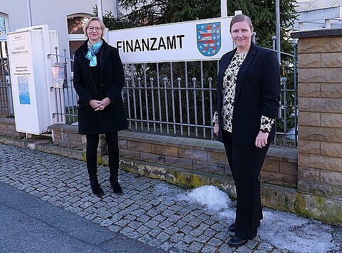 Finanzministerin Katja Wolf mit der stellvertretenden Amtsleitung des Finanzamts Südthüringen vor dem Eingang des Finanzamts.