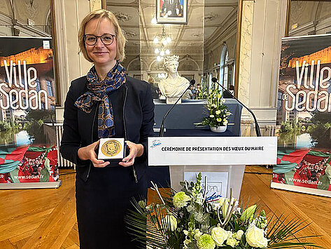 Finanzministerin Katja Wolf hält die Ehrenmedaille in der Hand
