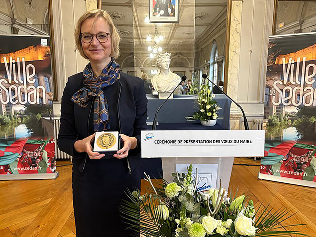 Finanzministerin Katja Wolf hält die Ehrenmedaille in der Hand