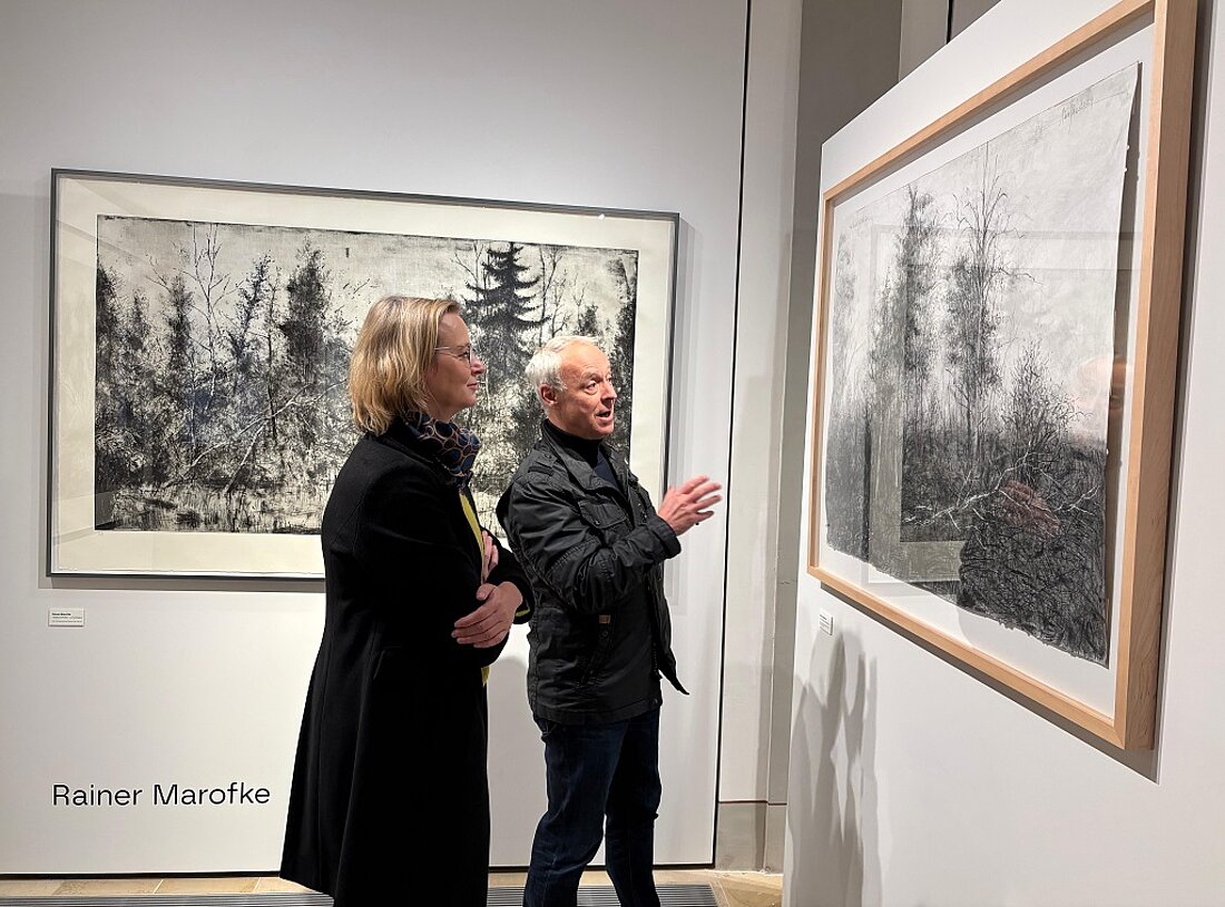 Finanzministerin Katja Wolf und Museumsleiter Dr. Reinhold Brunner betrachten gemeinsam ein Gemälde der Kunstausstellung "Gegenlicht" im Eisenacher Stadtschloss.