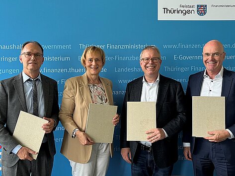 Staatssekretär des TMDI Dr. Tobias Knoblich, Geschäftsführerin der LEG Sabine Wosche, Finanzstaatssekretär Birger Scholz und Geschäftsführer der LEG Andreas Krey halten den unterzeichneten "Letter of Intent" in den Händen