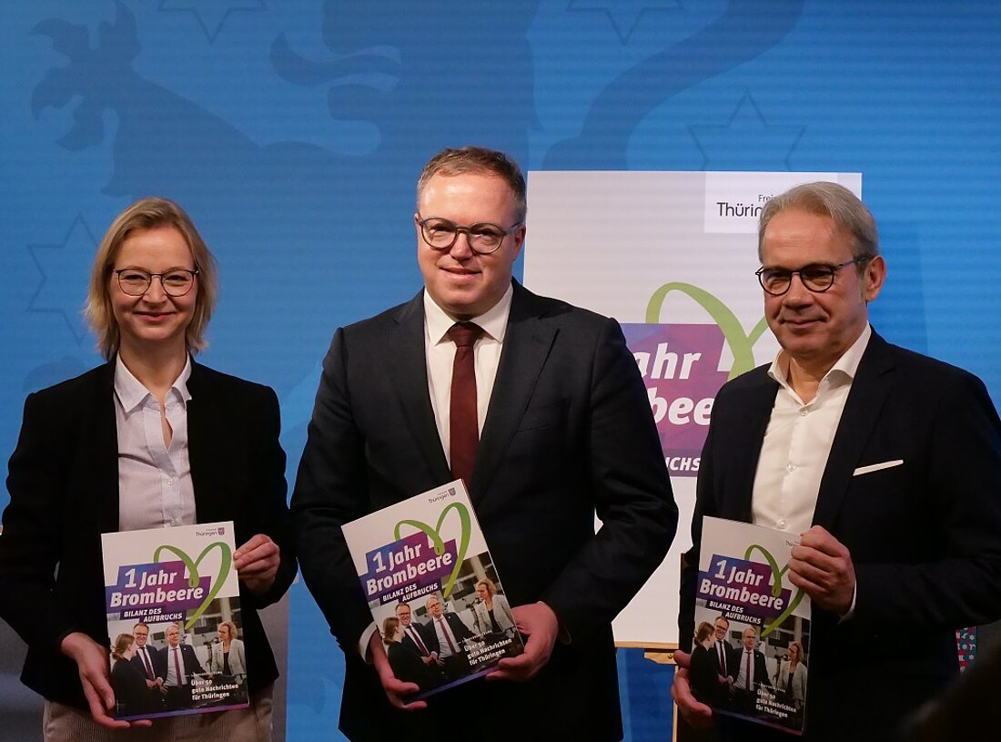 Auf dem Bild sieht man Finanzministerin und stellvertretende Ministerpräsidentin Katja Wolf gemeinsam mit Ministerpräsident Mario Voigt und Innenminister sowie stellvertretenden Ministerpräsidenten Georg Maier zur Pressekonferenz "1 Jahr Brombeere - Bilanz des Aufbruchs".