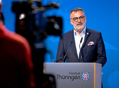 Finanzstaatssekretär Julian Vonarb und Amtschef vor einem Rednerpult bei der Regierungsmedienkonferenz