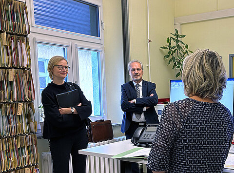 Finanzministerin Katja Wolf steht in einem Büro des Finanzamtes Eisenach und unterhält sich mit Bediensteten