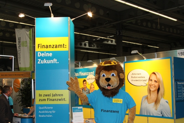 messestand_person_im_loewenkostuem.jpg Person mit Löwenkostüm steht vor dem Messestand der Thüringer Steuerverwaltung